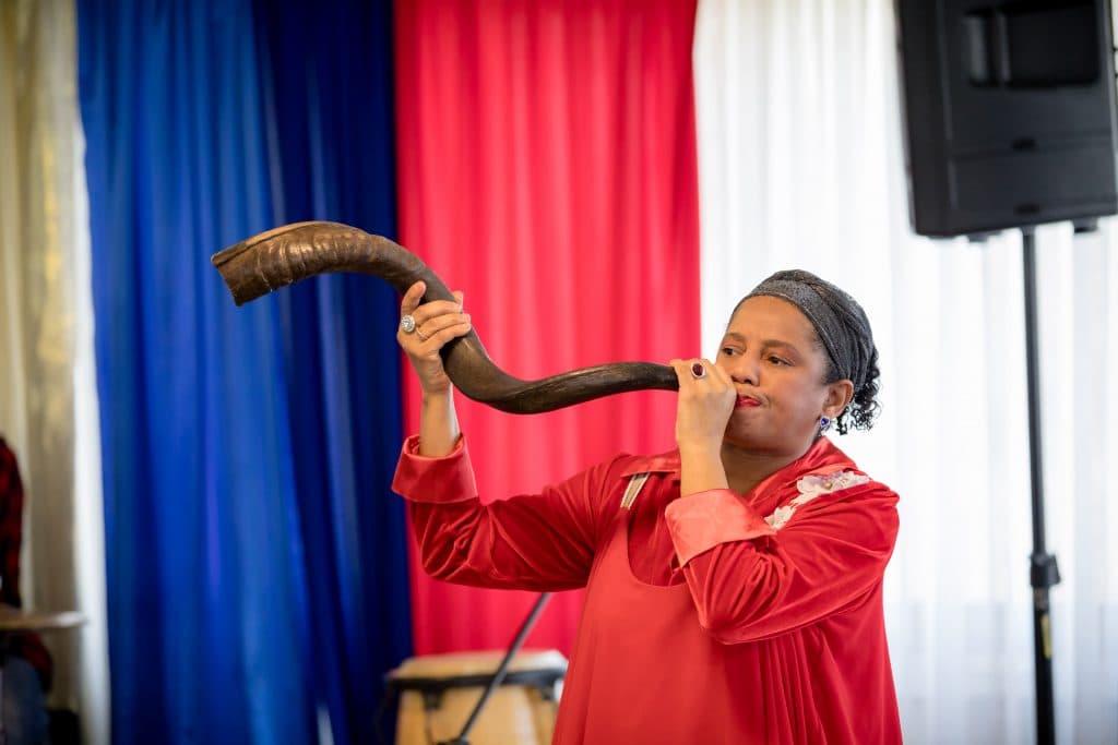 Een vrouw blaast op de sjofar