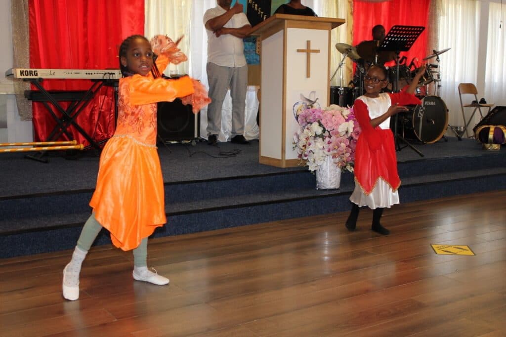 Kinderen dansen voorin de zaal